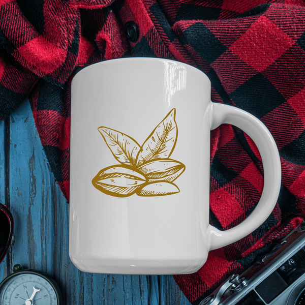 White ceramic mug with gold botanical seed and leaf design on rustic blue wooden table