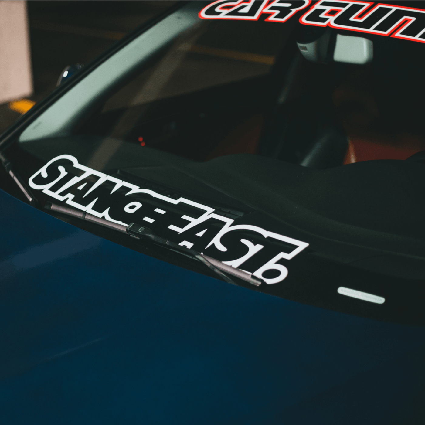 UV DTF car windshield sticker with bold white text, close-up view.